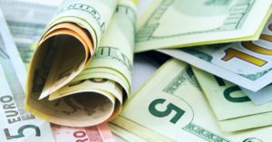 Bunch of dollar bills on the table forming a heart shape