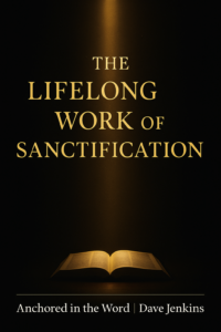 An open Bible illuminated by a vertical beam of warm golden light against a dark charcoal background, with the title ‘The Lifelong Work of Sanctification’ in gold serif text above and ‘Anchored in the Word | Dave Jenkins’ in white text below, symbolizing the refining work of sanctification.