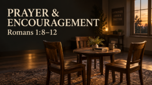 Three wooden chairs around a table in a warmly lit church fellowship space, representing prayer and mutual encouragement in Romans 1:8–12.